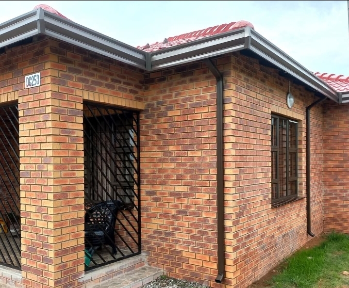 Charcoal gutters and downpipe on a face brick house